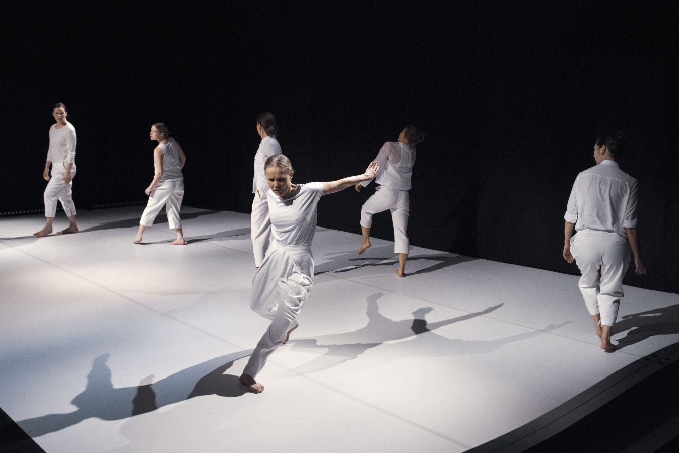 Sex dansare dansar på en vit dansmatta.